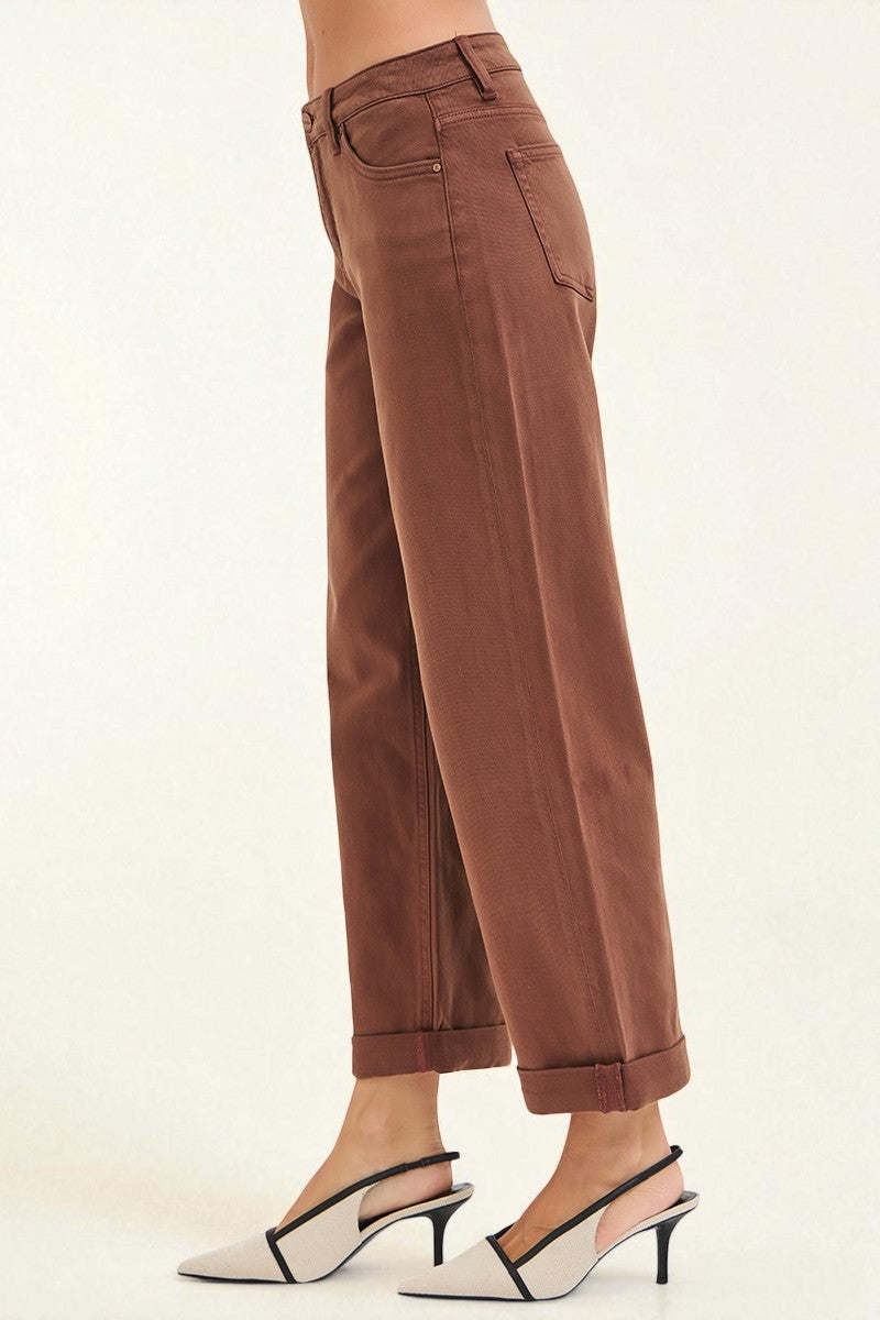 Brown pants worn by a person on a white background