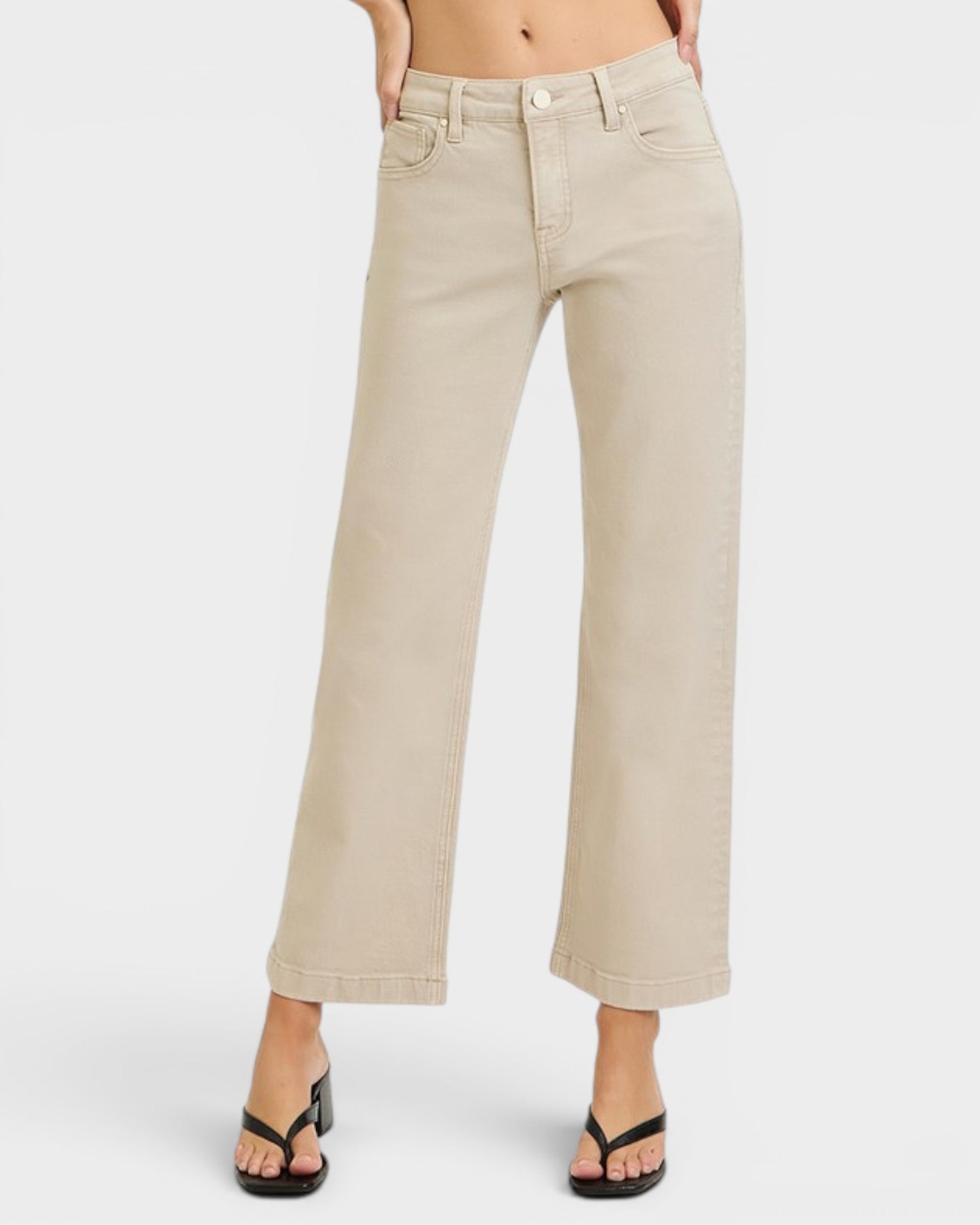 Beige wide-leg jeans worn by a person on a white background