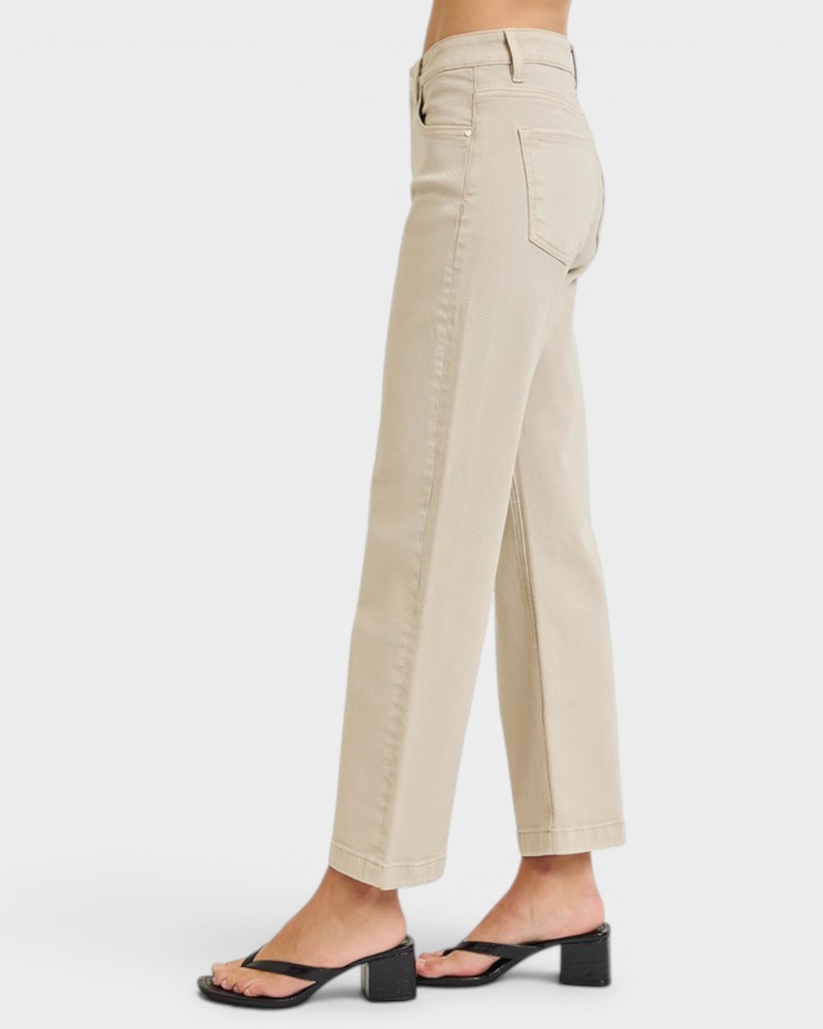 Beige pants worn by a person on a white background