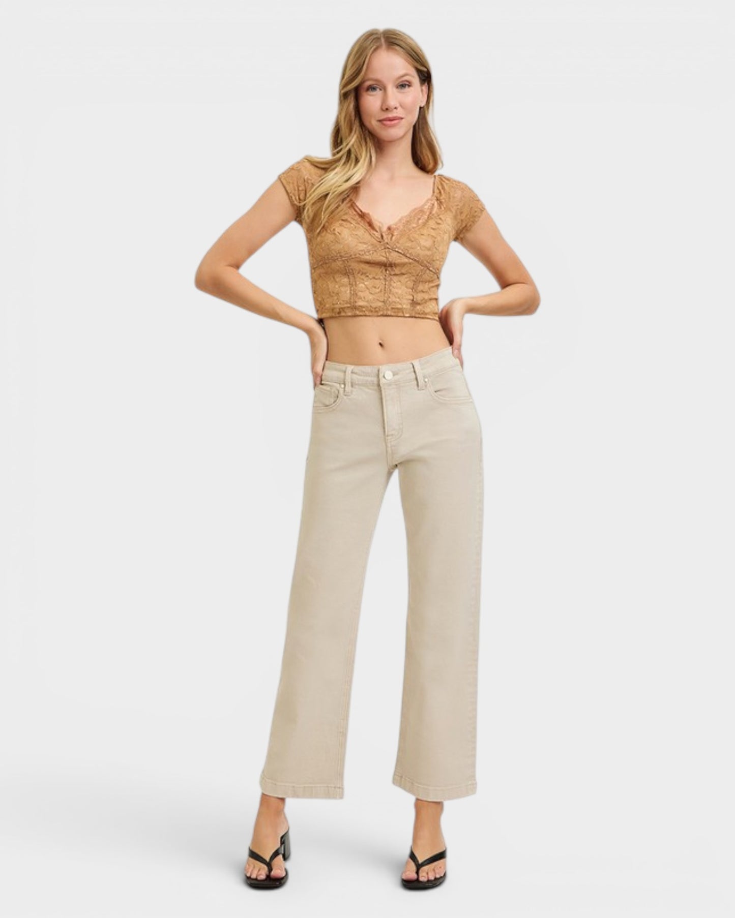 Woman wearing a beige top and pants on a white background