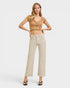Woman wearing a beige top and pants on a white background