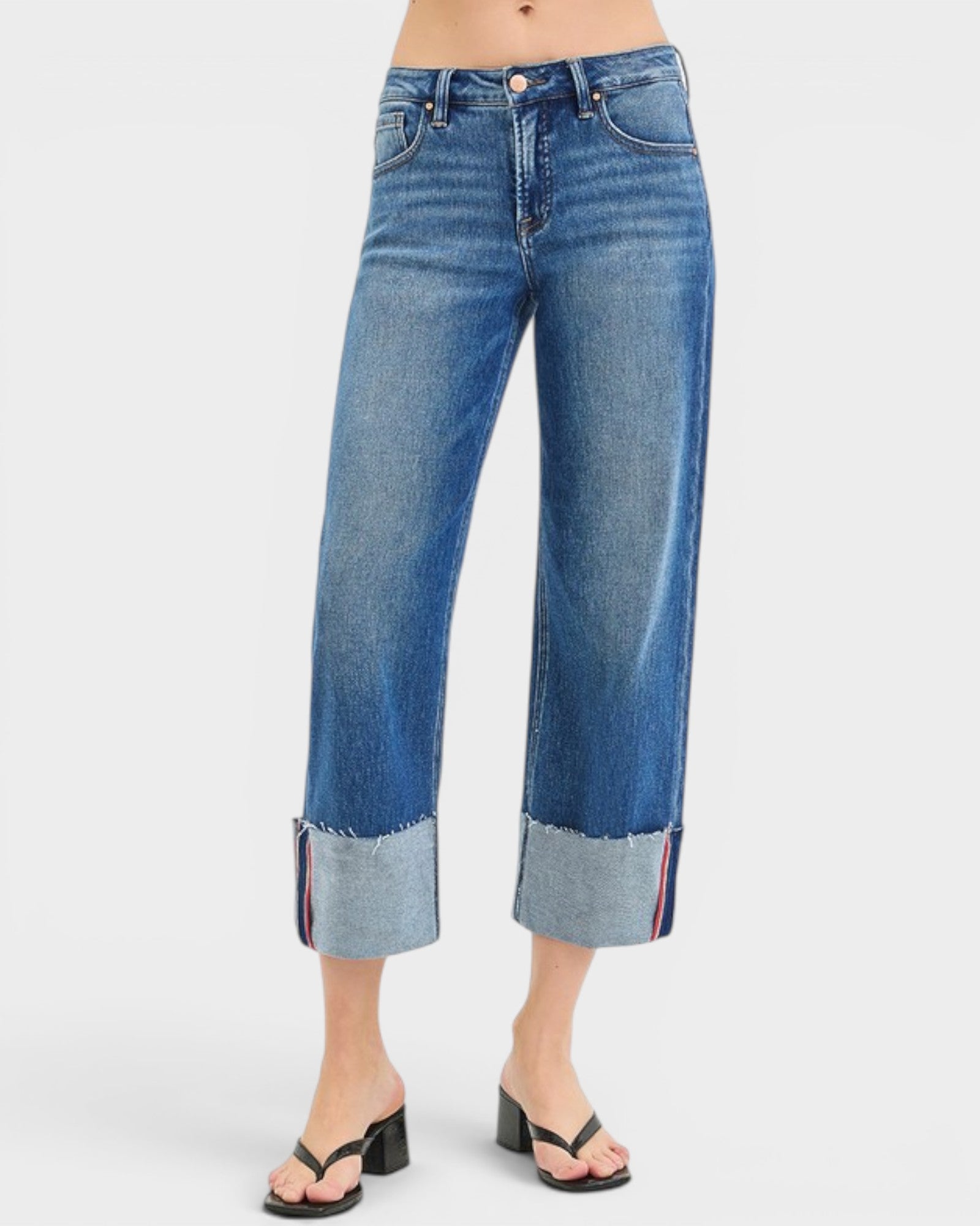 Blue jeans with rolled-up cuffs on a white background