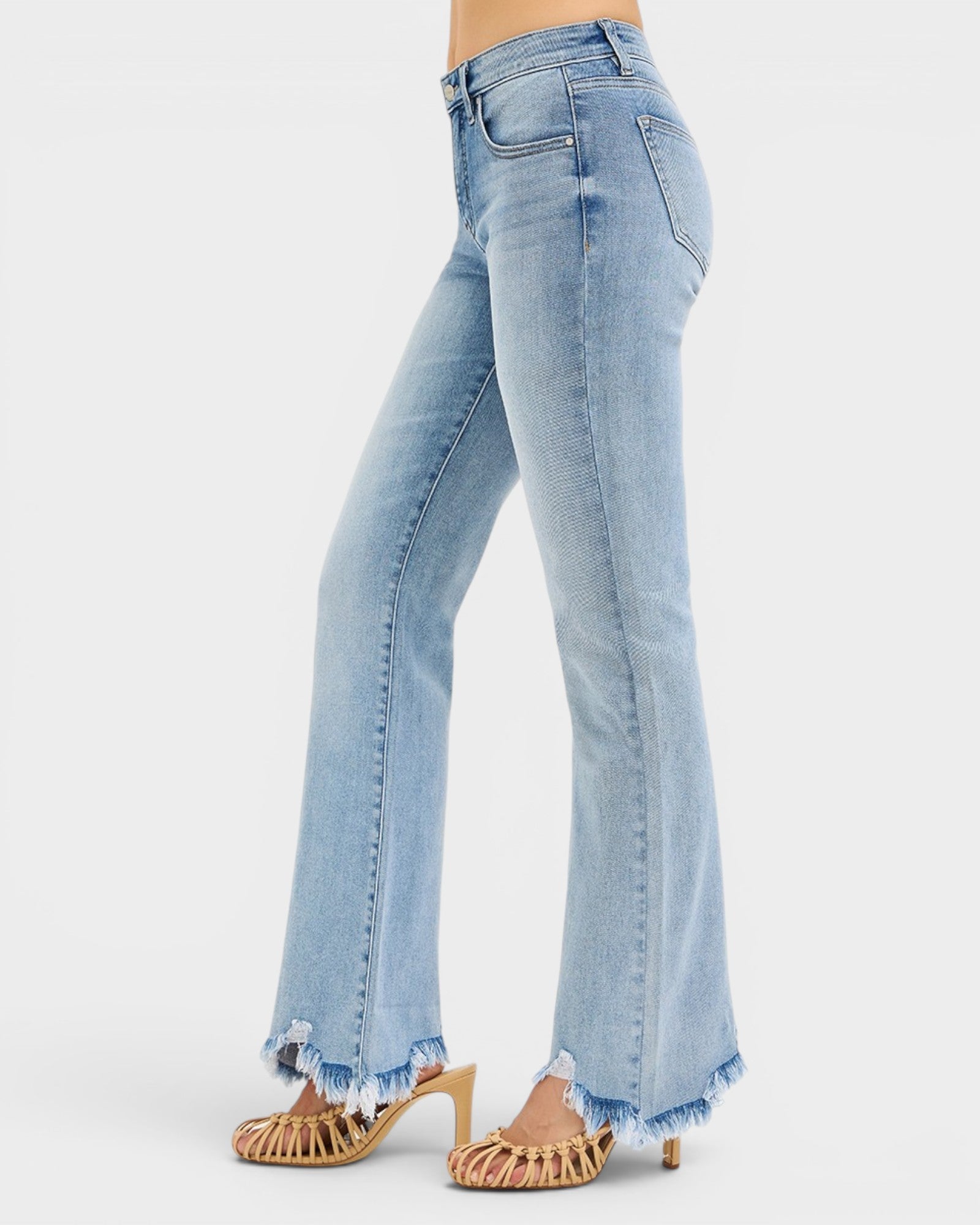Light blue jeans with frayed hem on a white background