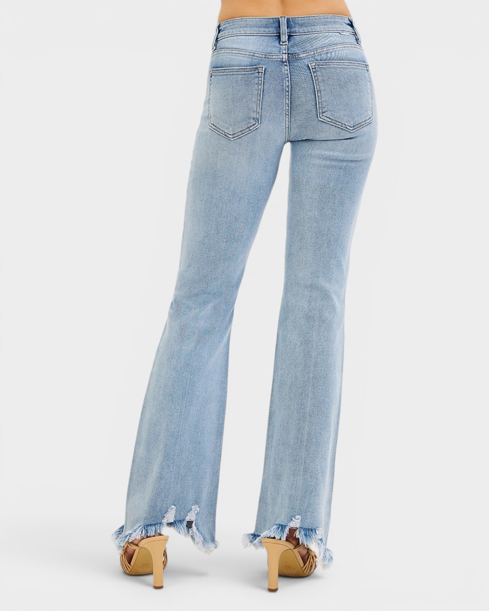 Light blue flared jeans with frayed hems on a white background