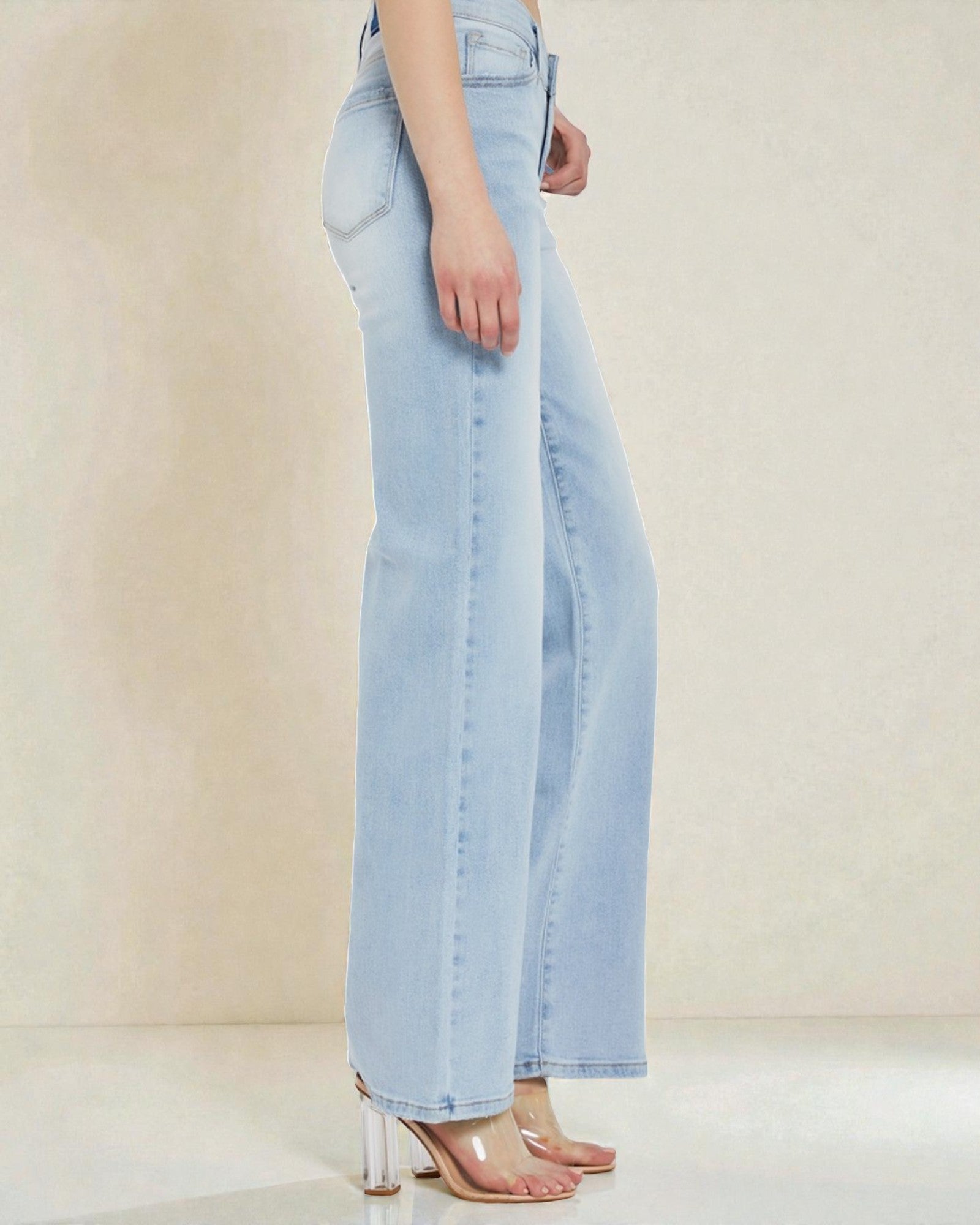 Light blue jeans worn by a person on a plain background