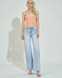 Woman wearing a strapless top and light blue jeans on a white background