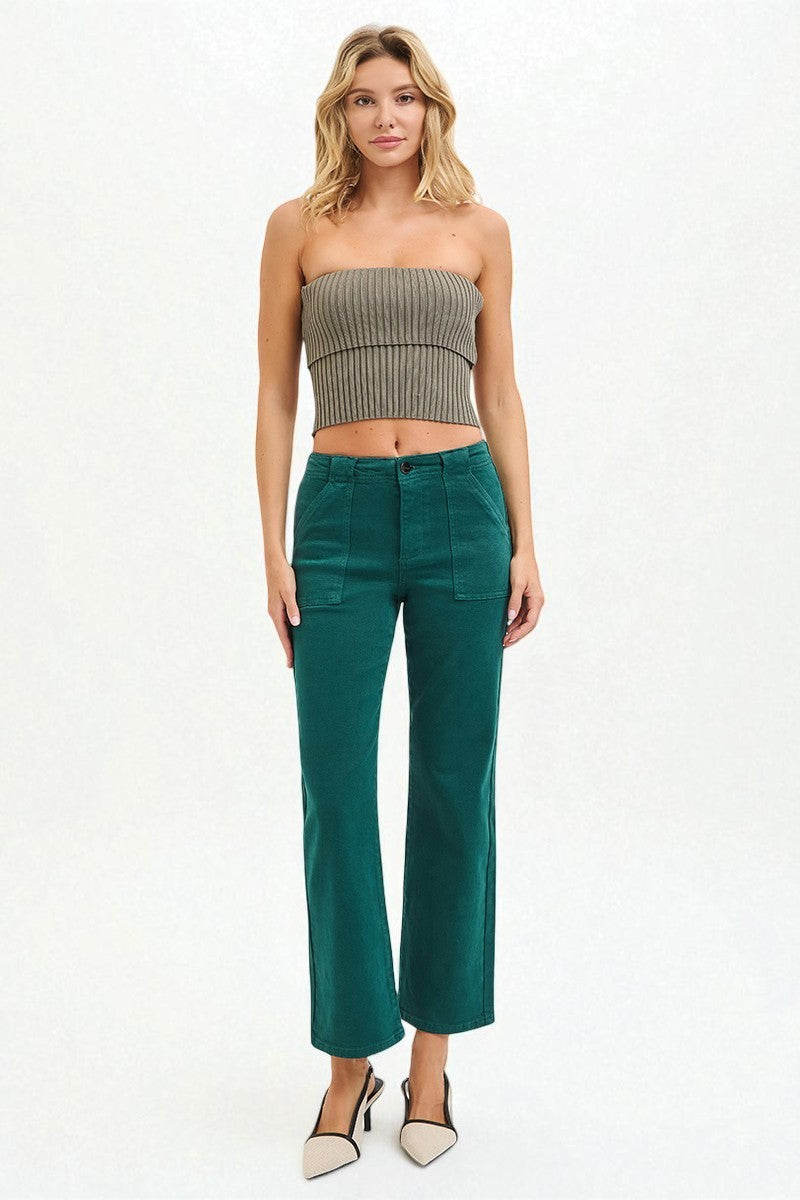 Woman wearing a strapless top and teal pants on a white background