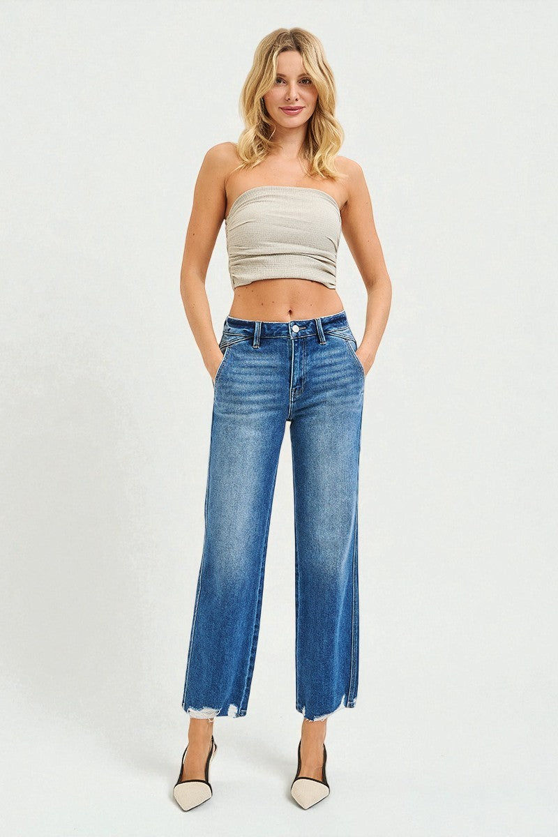 Woman wearing a strapless top and blue jeans on a white background