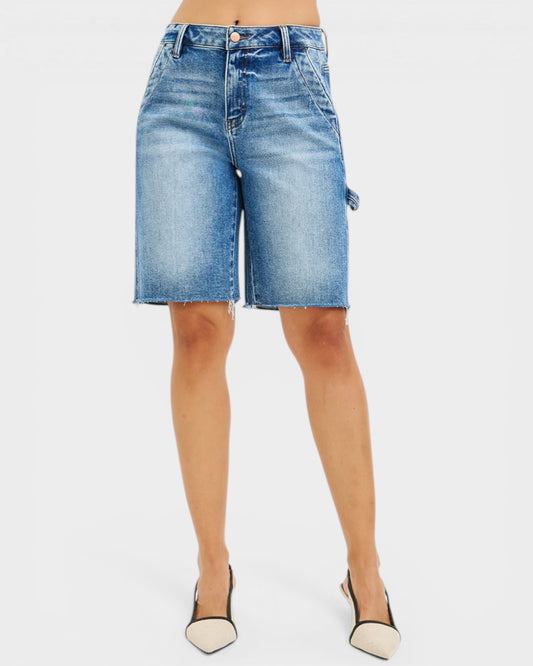 Denim shorts worn by a person on a white background