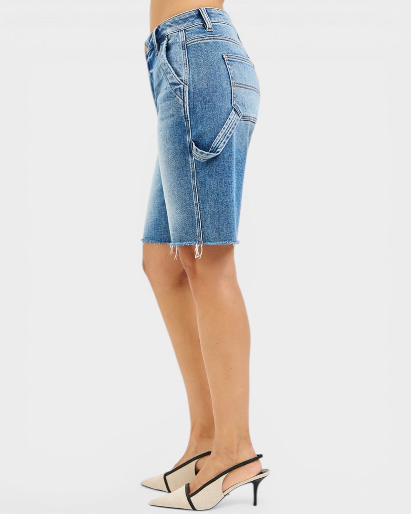 Denim shorts worn by a person on a white background