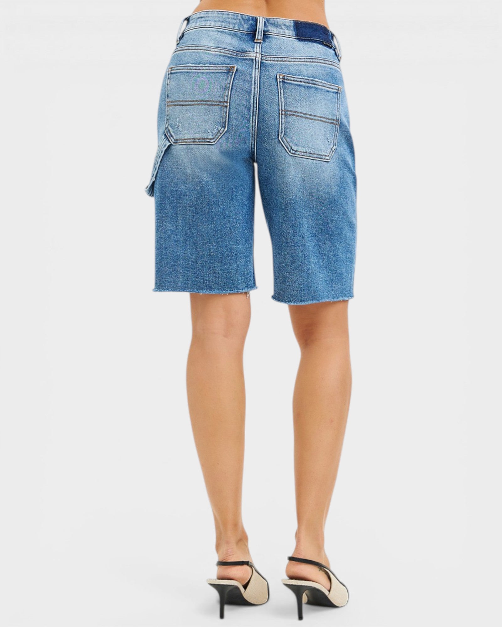 Blue denim shorts worn by a person on a white background