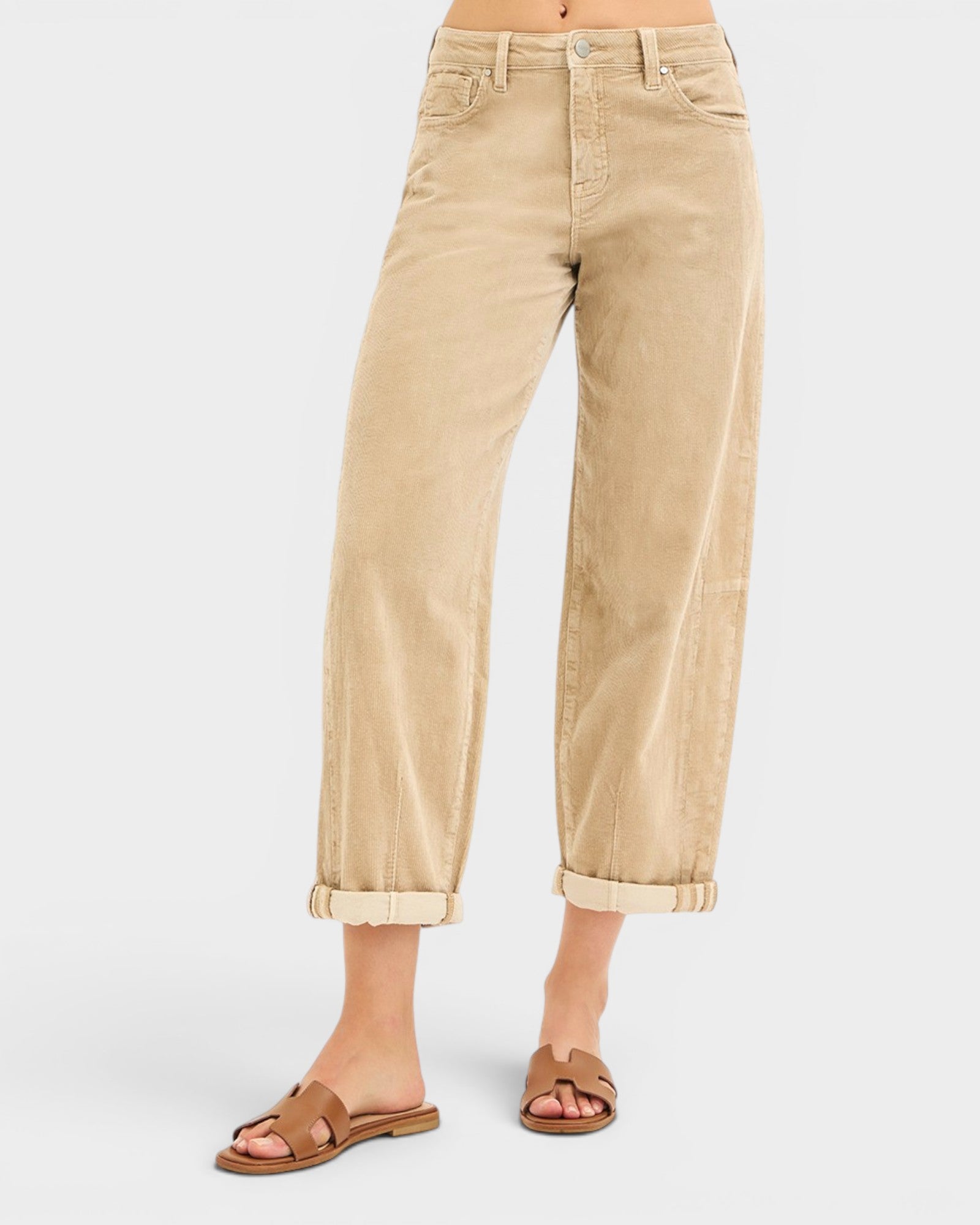 Beige pants worn by a person on a white background