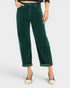 Green corduroy pants worn by a person on a white background