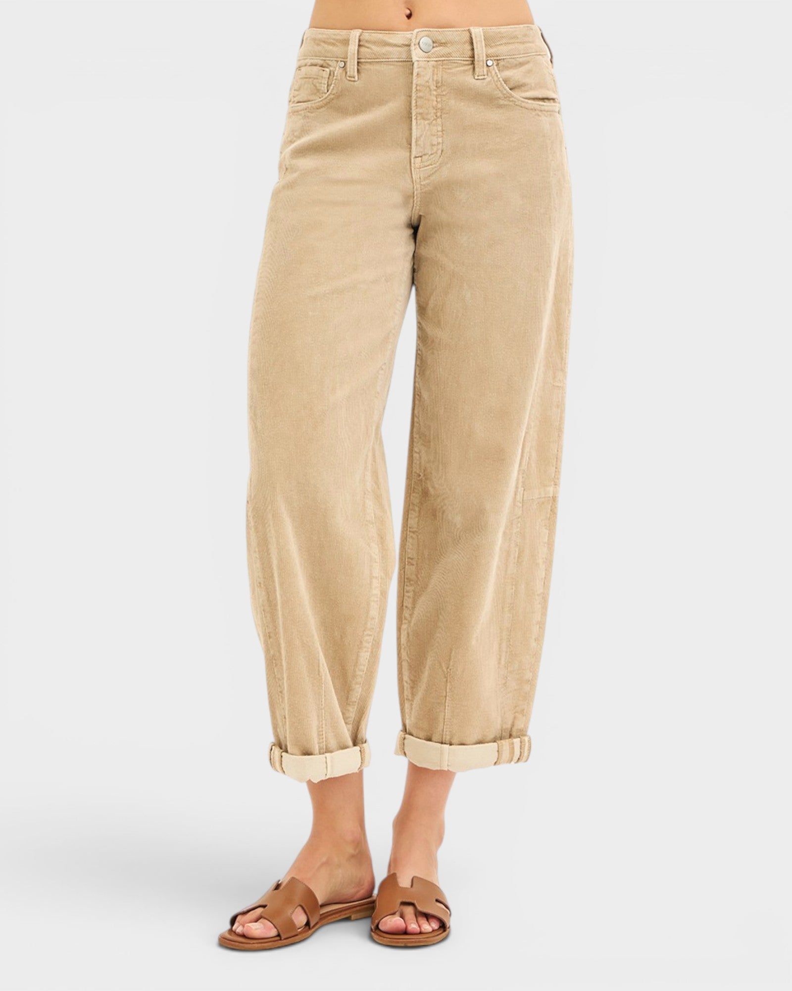 Beige pants worn by a person on a white background