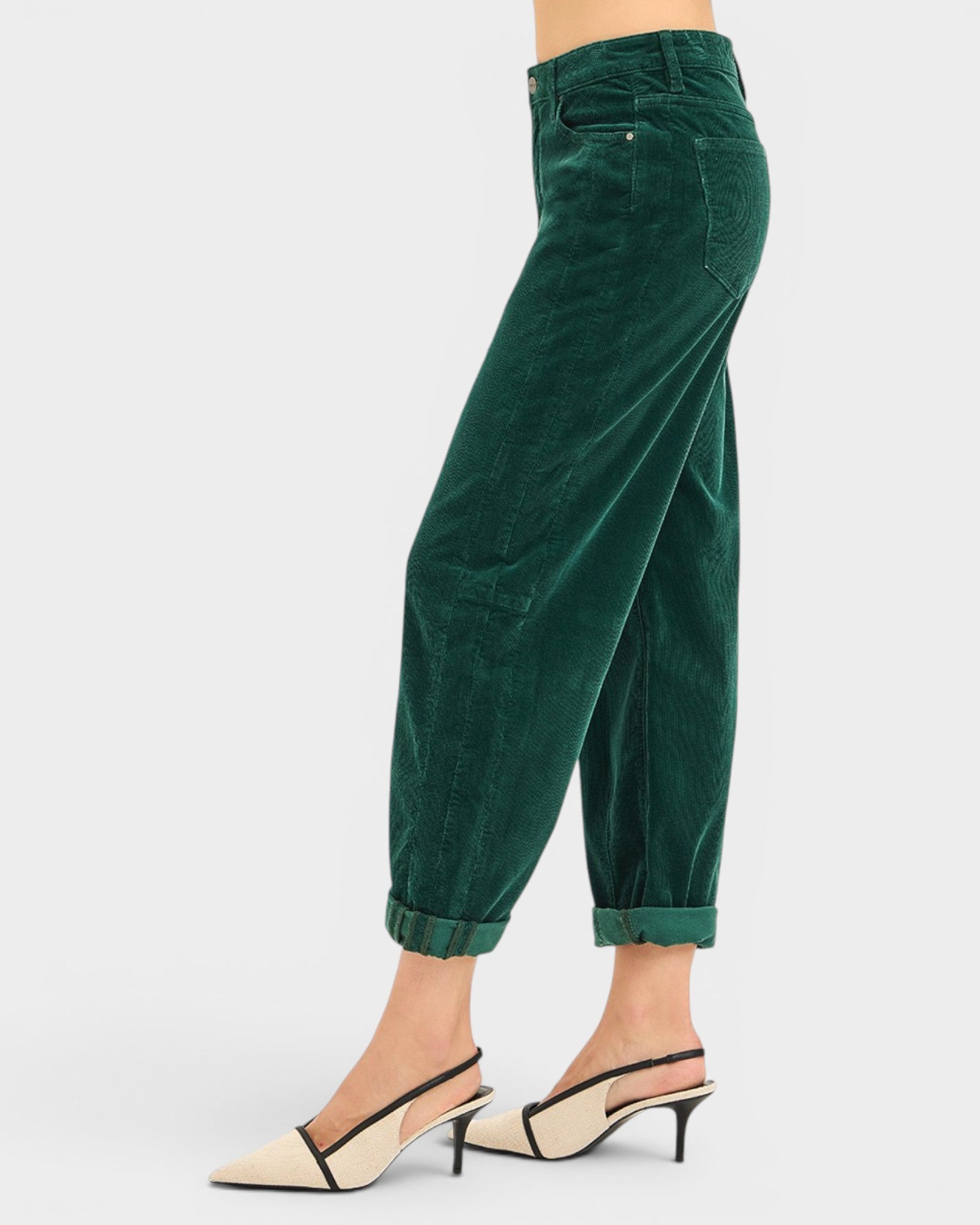 Green corduroy pants worn by a person on a white background