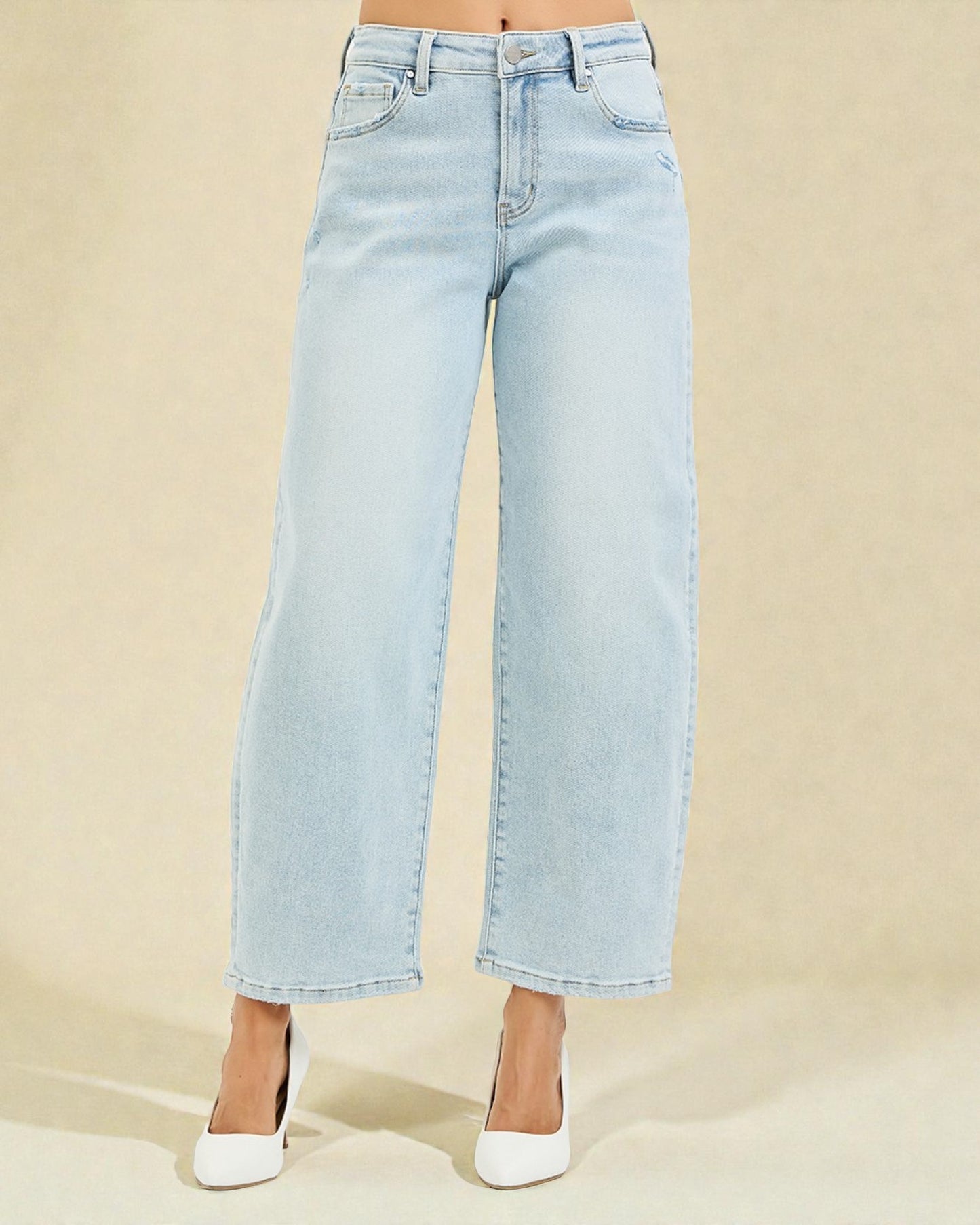 Light blue jeans worn by a person on a beige background