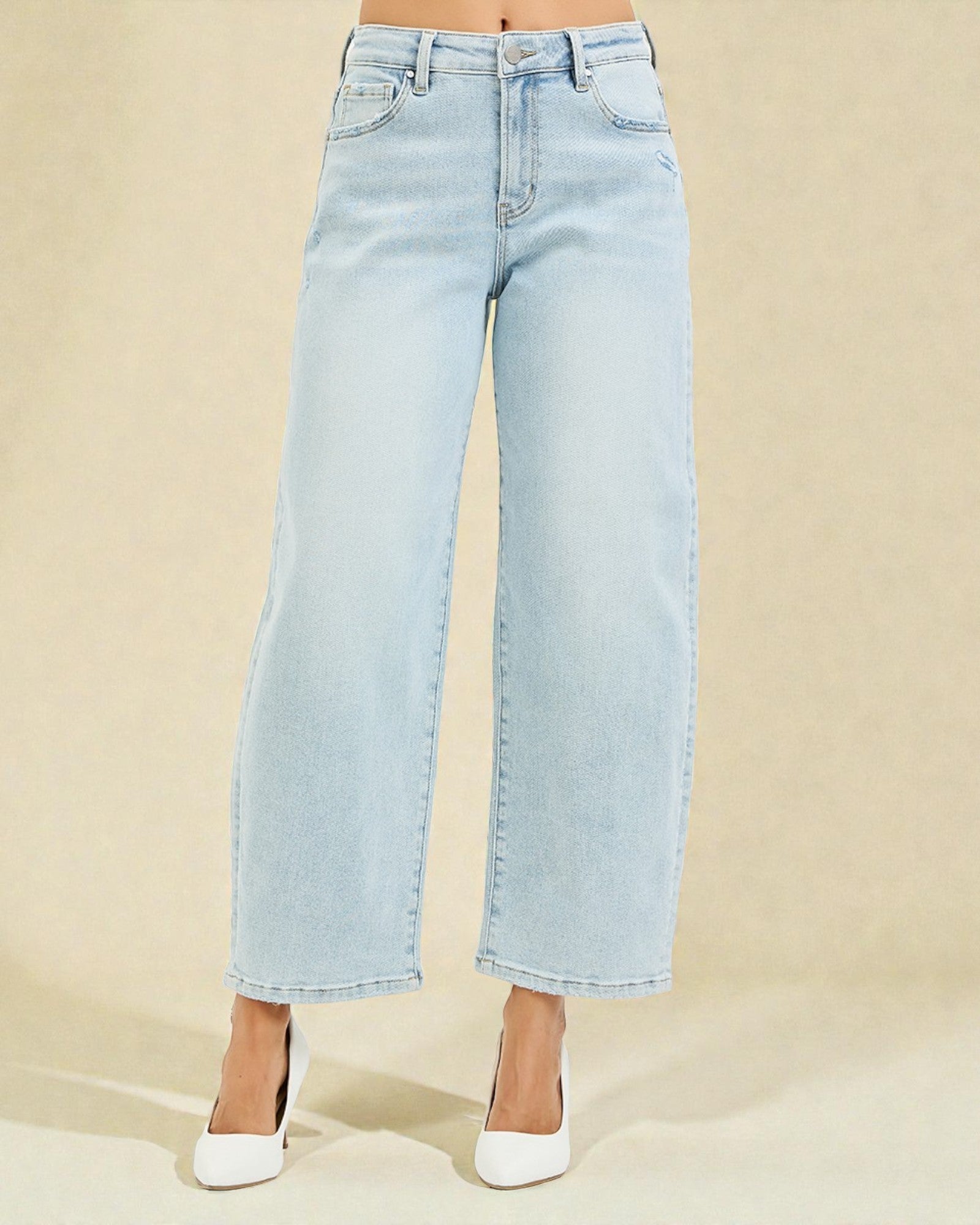 Light blue jeans worn by a person on a beige background