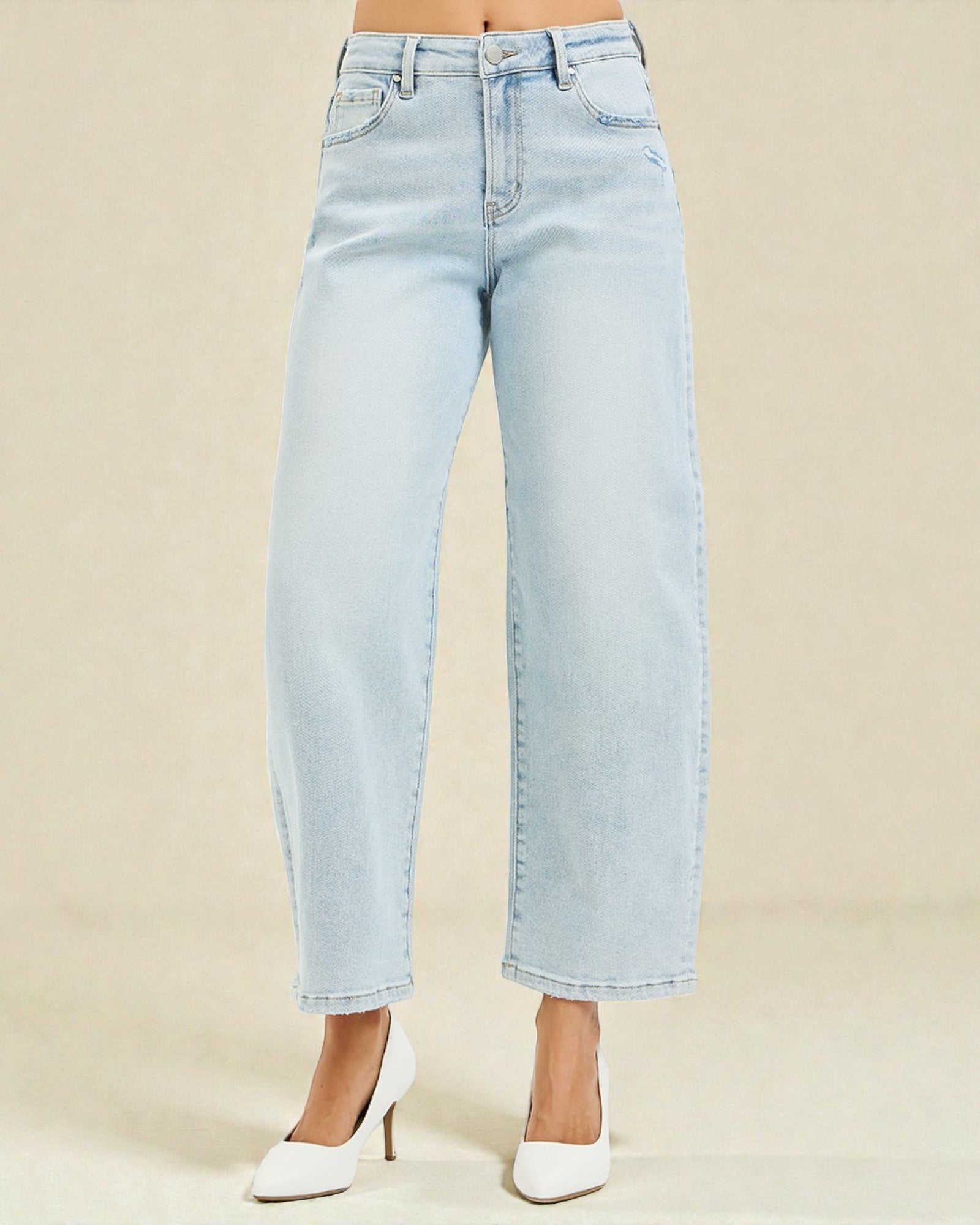 Light blue jeans worn by a person on a beige background