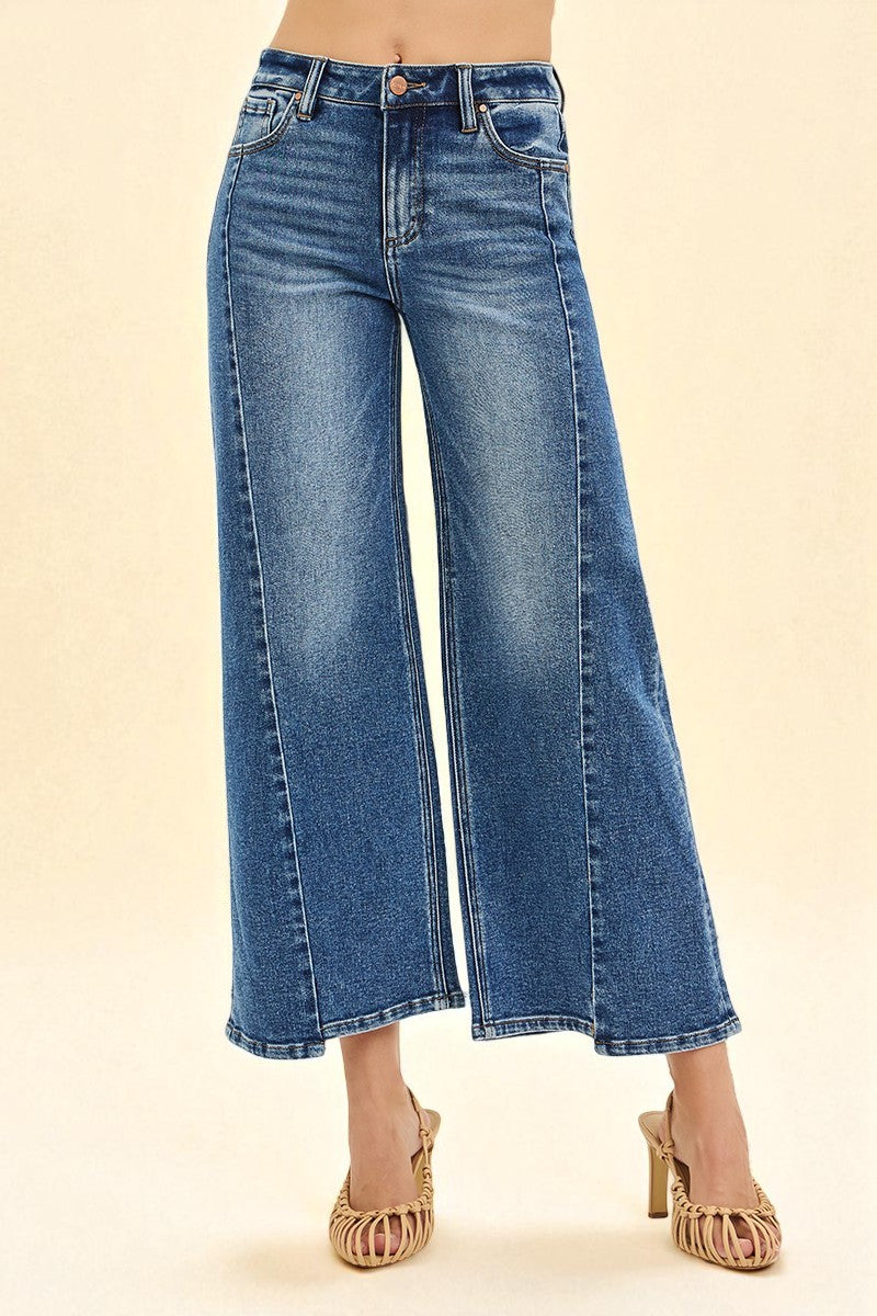 Blue jeans worn by a person on a beige background