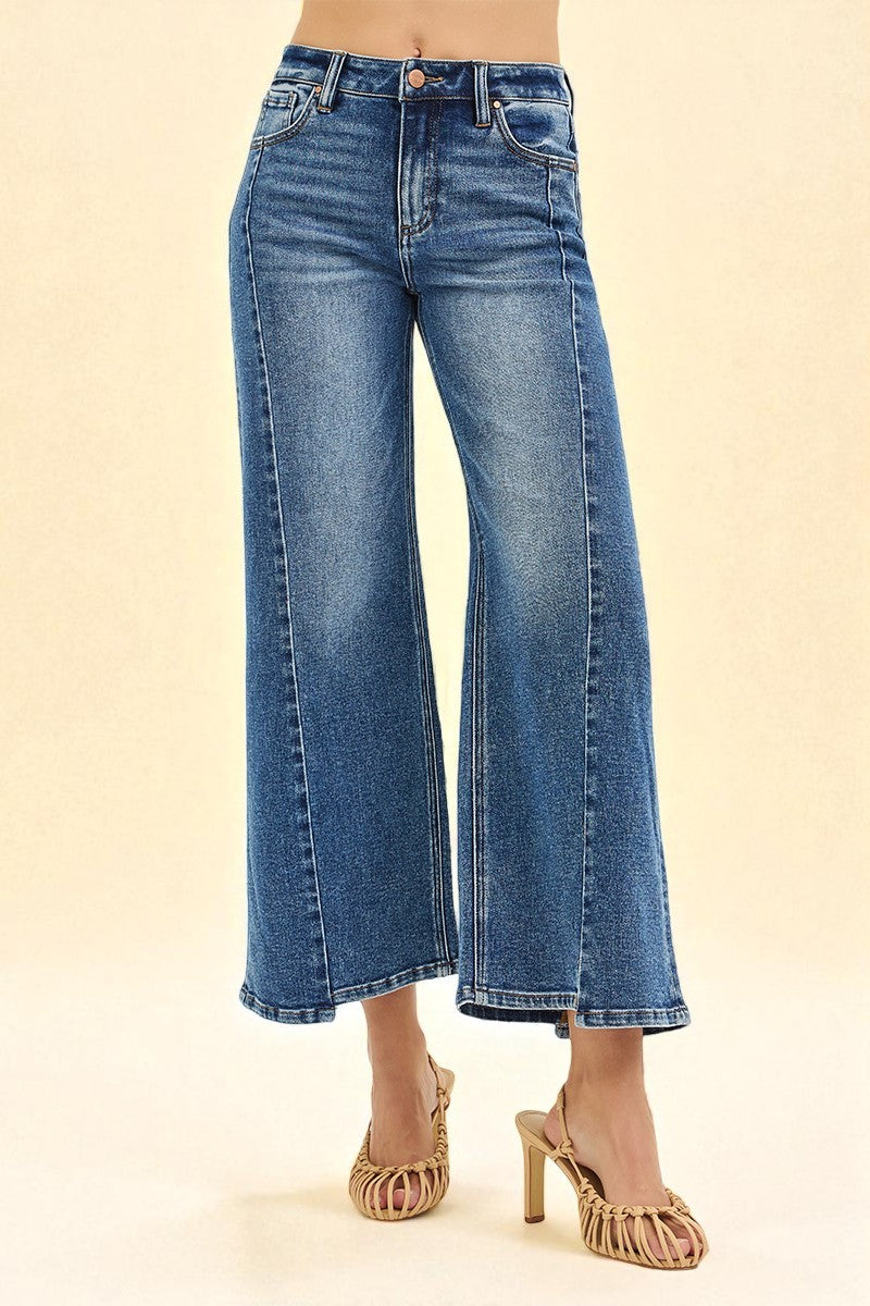 Blue jeans worn by a person on a beige background