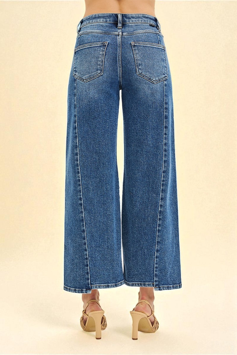 Blue jeans worn by a person on a beige background