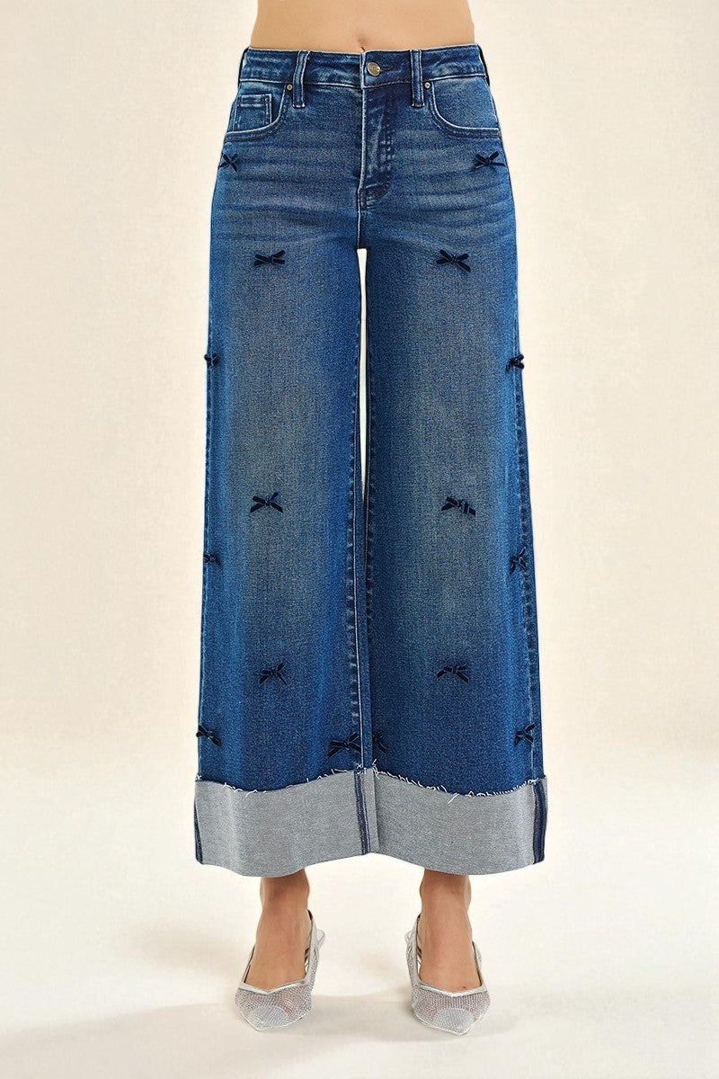 Wide-leg jeans with decorative elements on a beige background