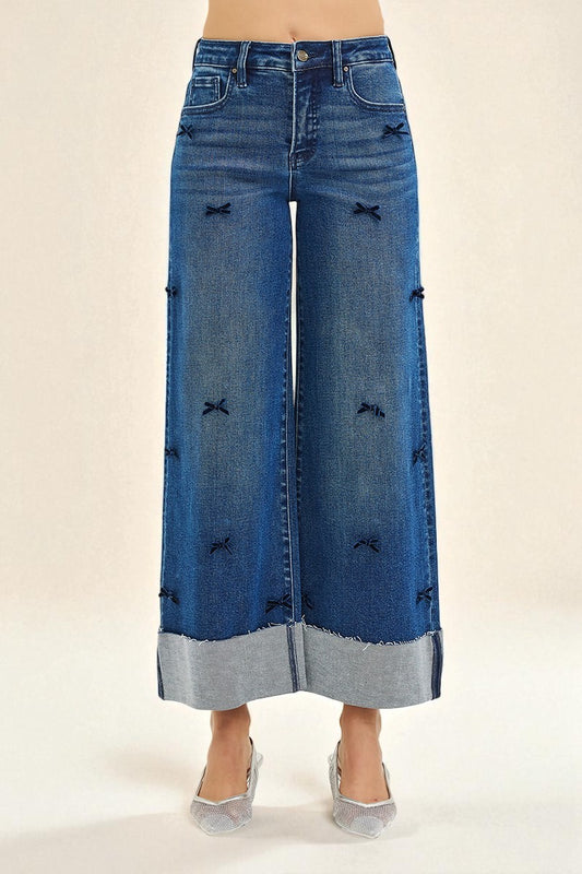 Wide-leg jeans with decorative elements on a beige background