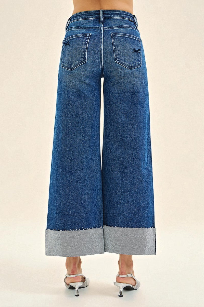 Blue wide-leg jeans with a gray hem on a beige background