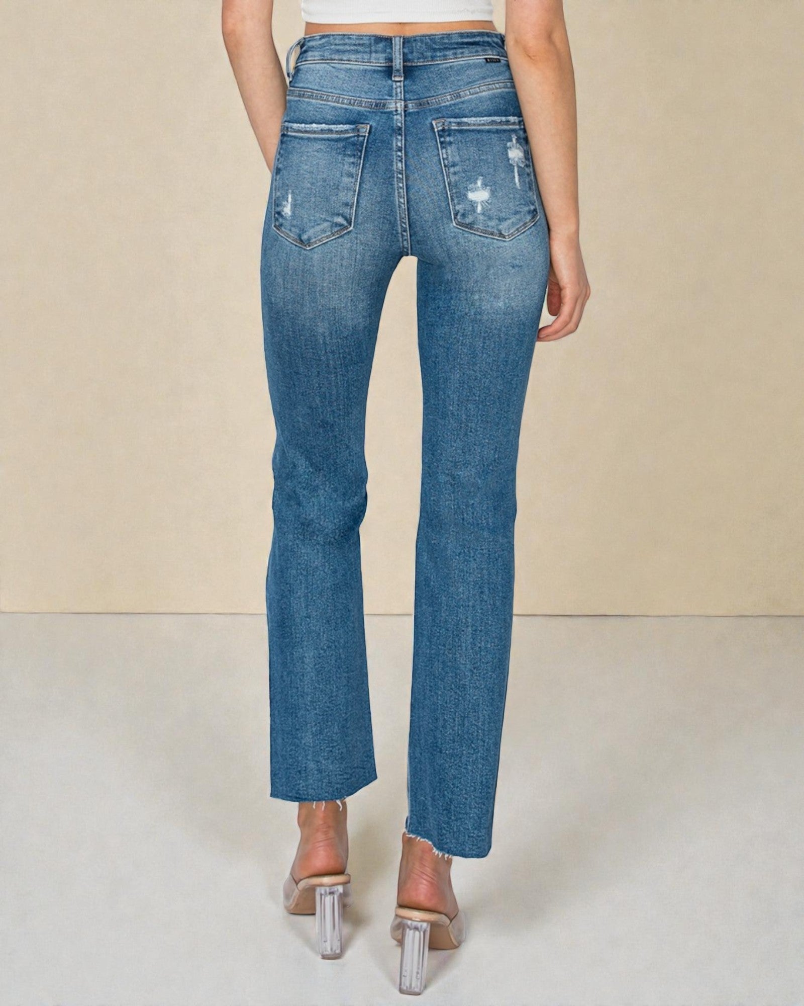 Blue jeans worn by a person on a plain background