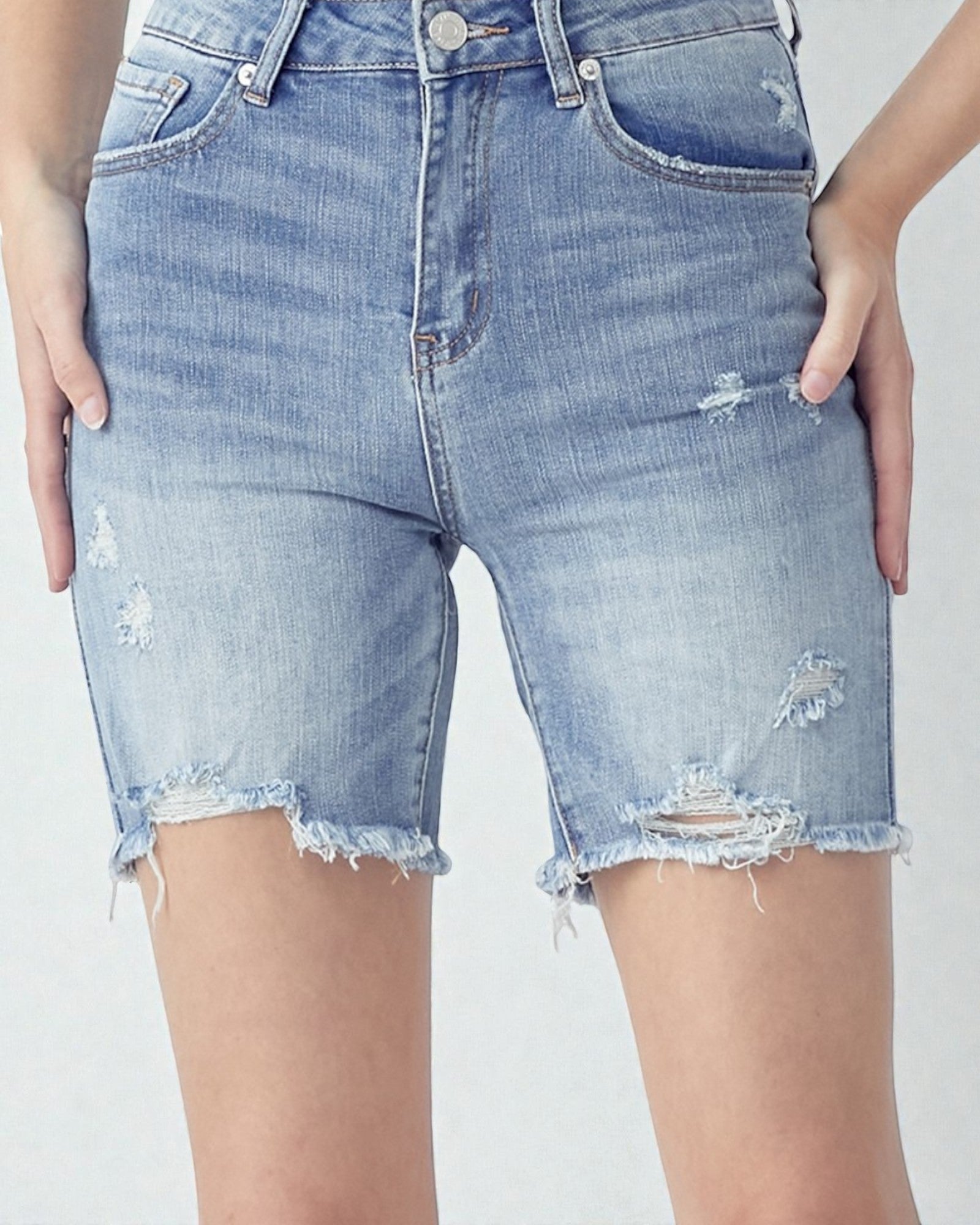Light blue denim shorts with slight distressing on a plain background