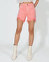 Person wearing pink denim shorts on a white background