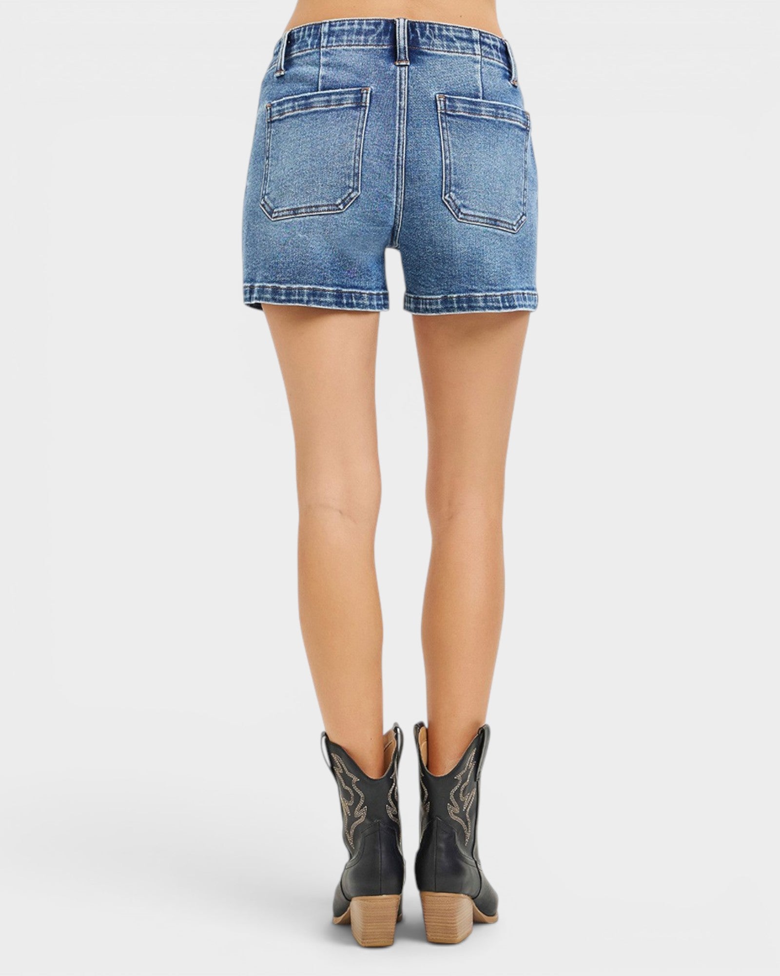 Person wearing blue denim shorts on a white background