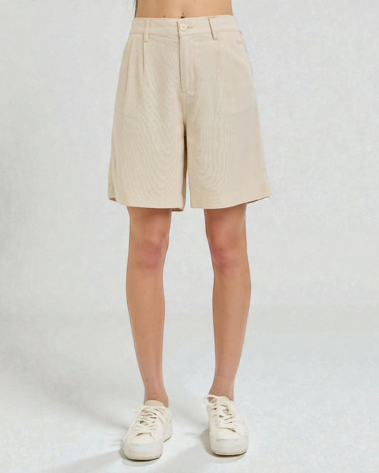 Beige shorts worn by a person on a white background