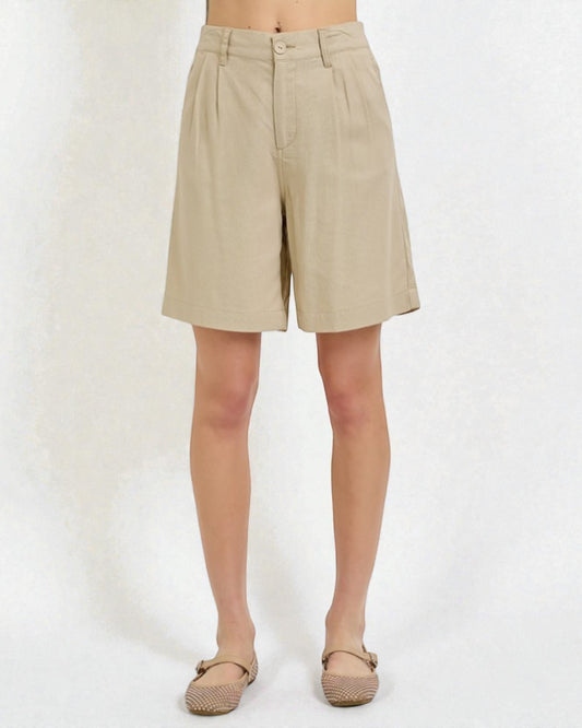 Beige shorts worn by a person on a white background