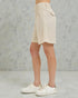 Beige shorts worn by a person on a gray background
