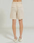 Beige shorts worn by a person on a plain background
