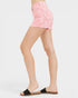 Person wearing pink denim shorts on a white background