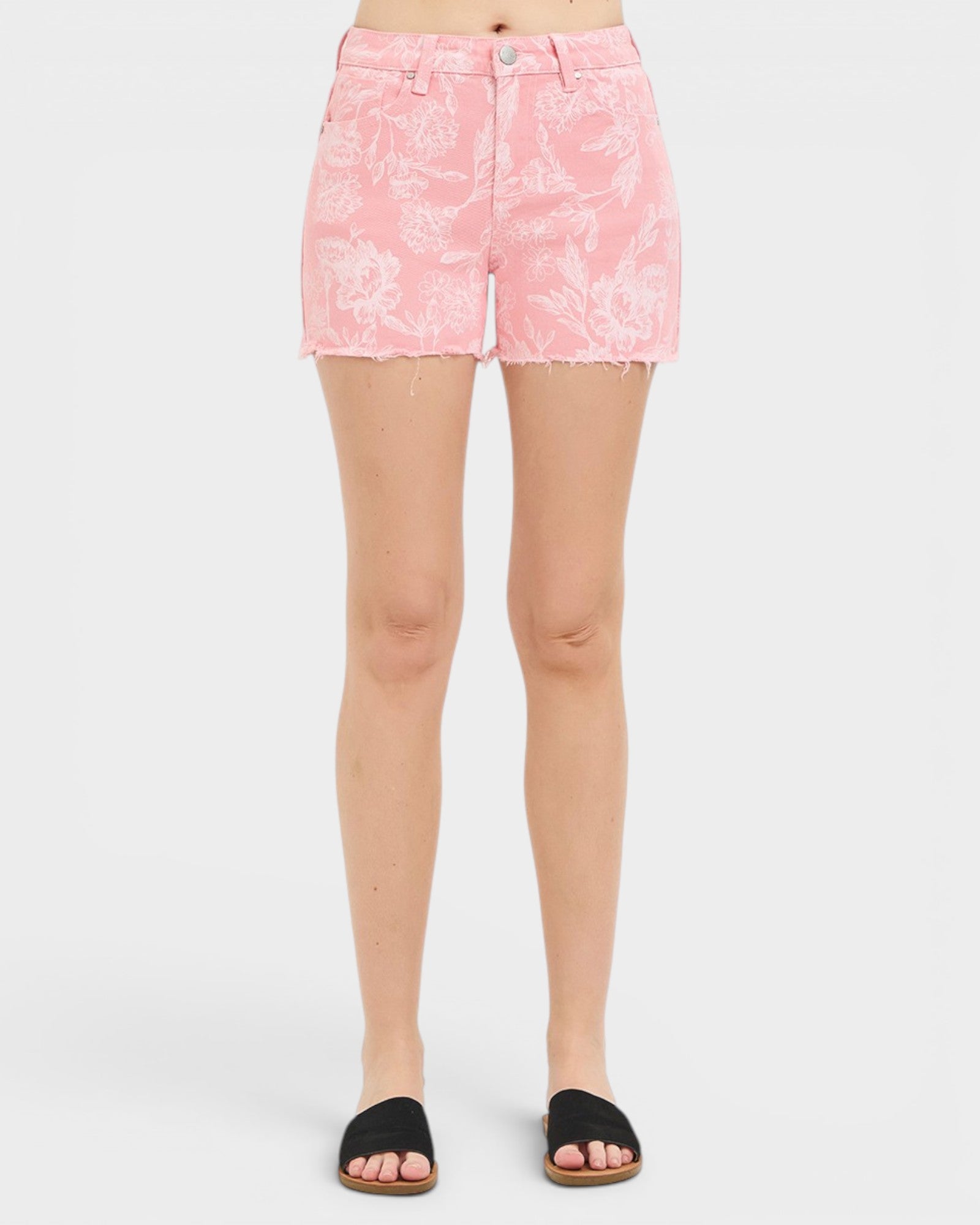 Person wearing pink floral shorts on a white background