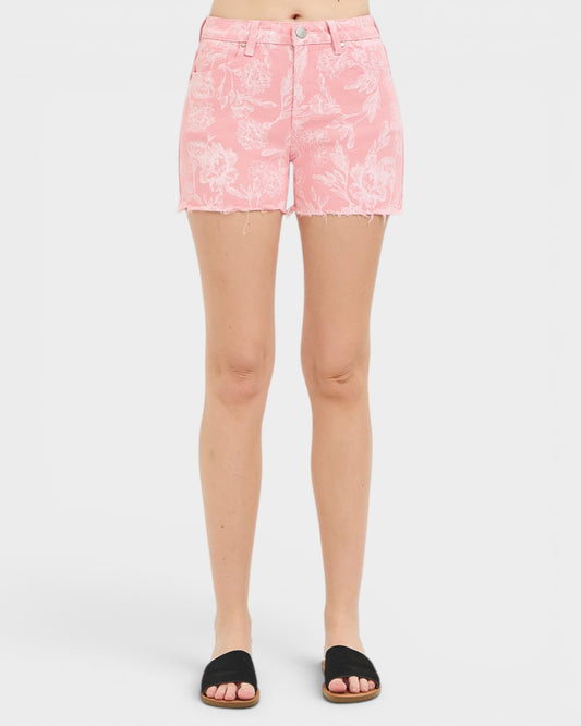 Person wearing pink floral shorts on a white background