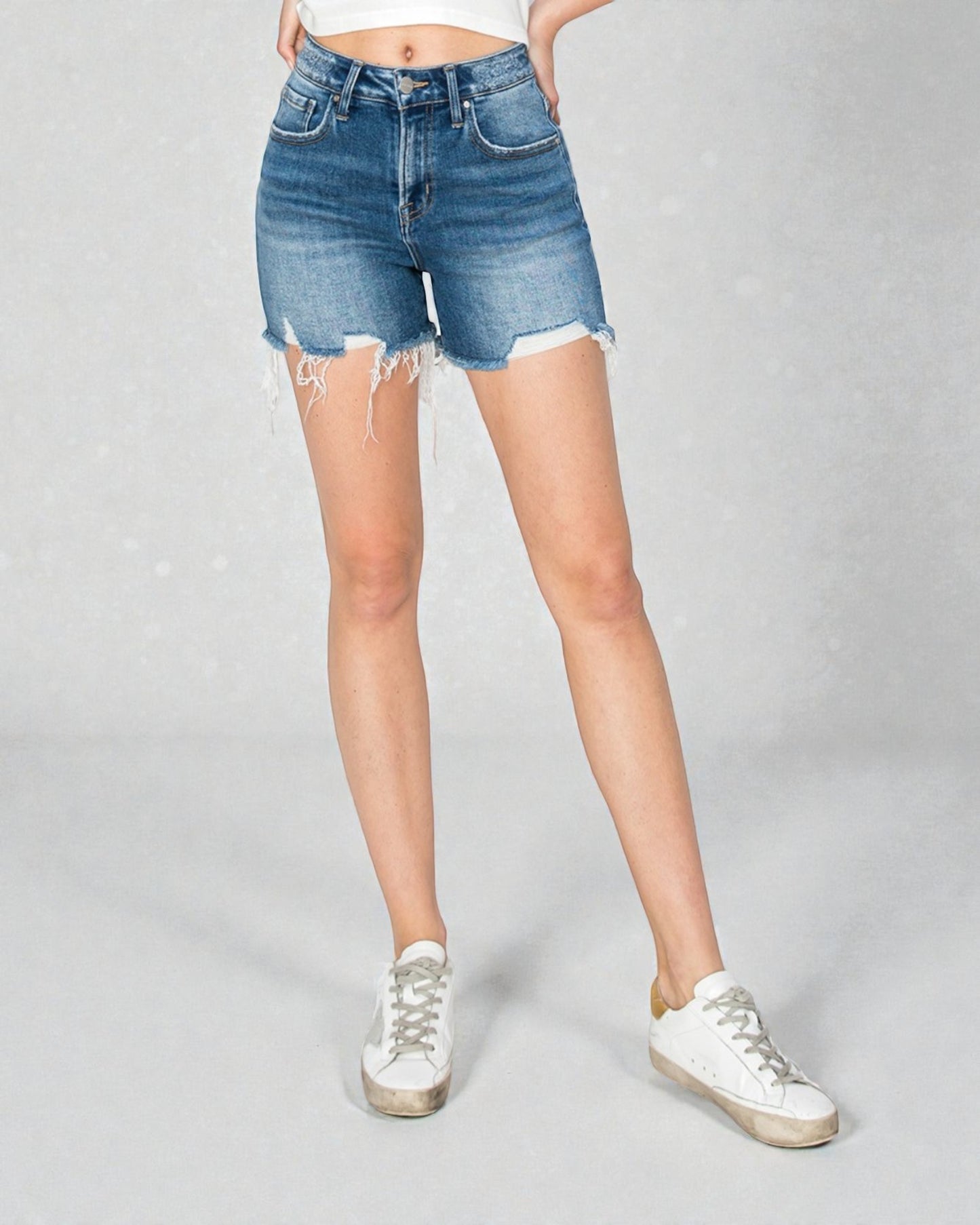 Person wearing blue denim shorts on a gray background