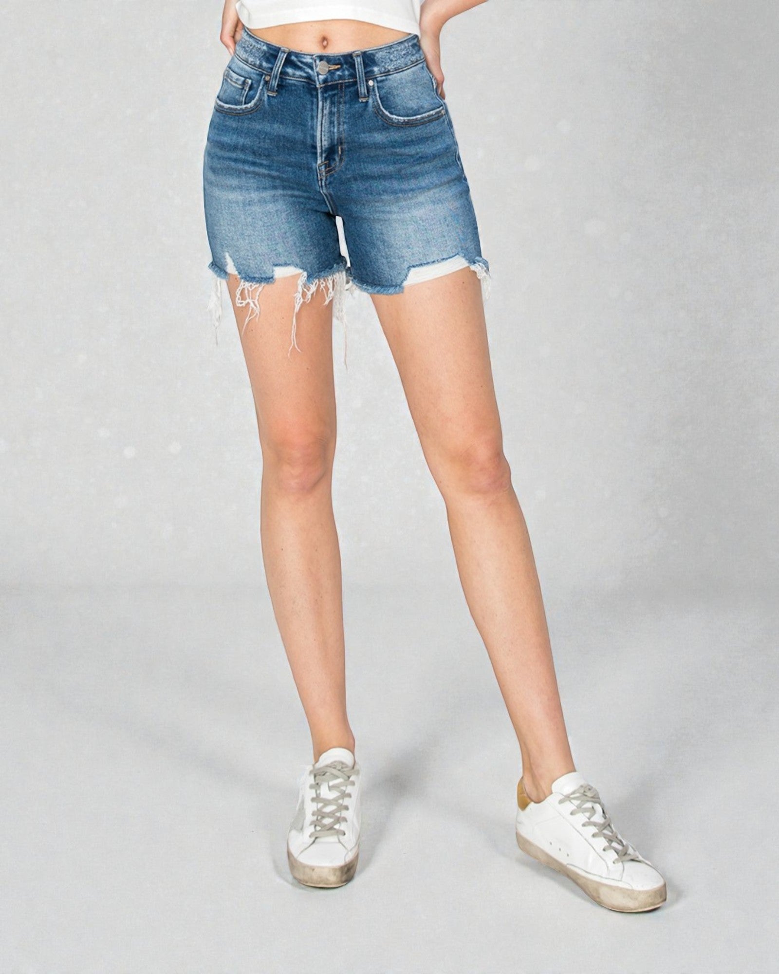 Person wearing blue denim shorts on a gray background