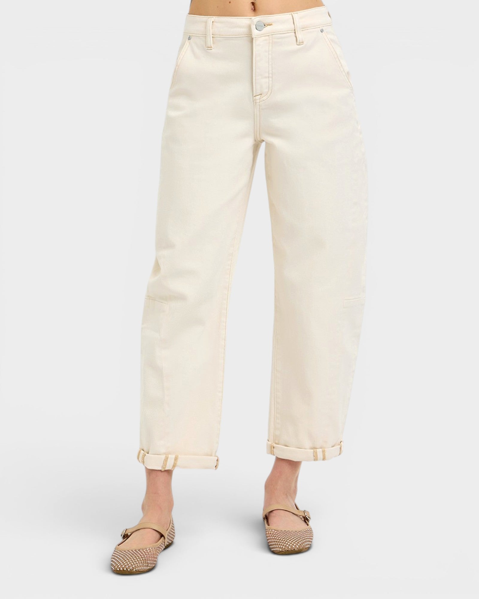Person wearing cream-colored jeans on a white background