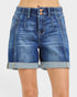 Blue denim shorts with rolled-up hem on a white background