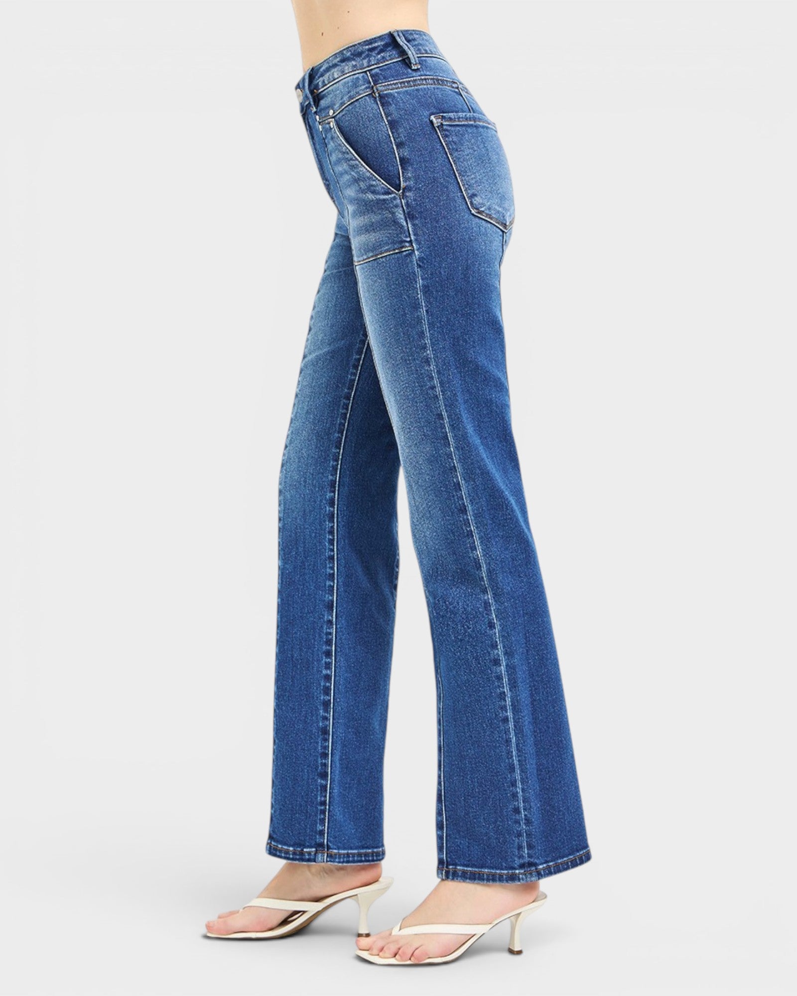 Blue jeans being worn on a plain background