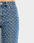 Blue jeans with white bow pattern on a light gray background