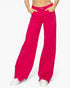 Bright fuchsia pink wide-leg jeans modeled from the waist down, paired with white sneakers, on a clean white background.