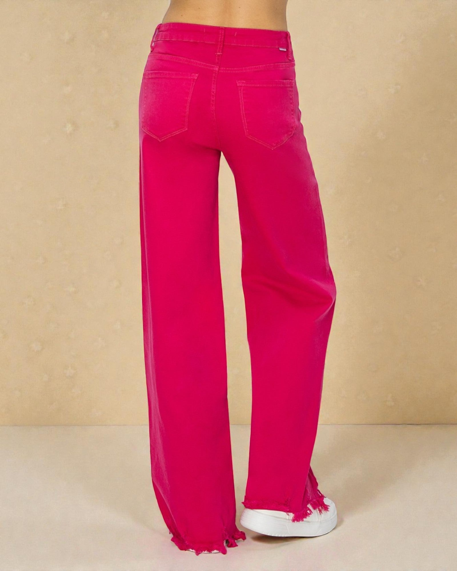 Bright pink wide-leg jeans on a beige background