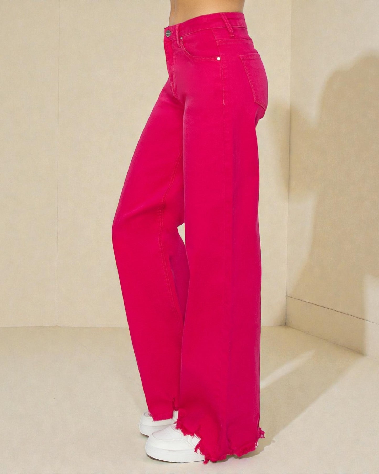 Bright pink jeans worn by a person on a neutral background