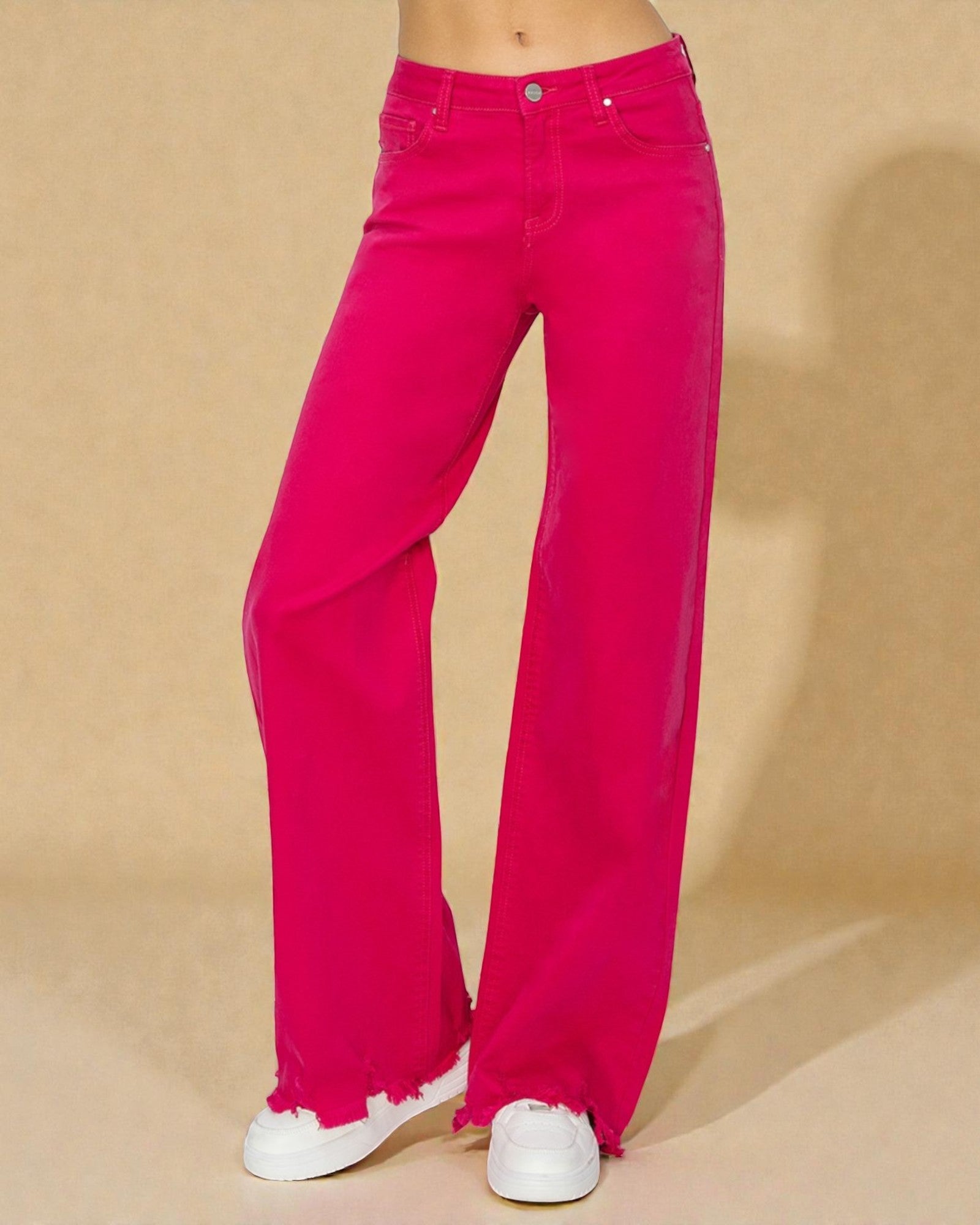 Bright pink wide-leg jeans worn by a person on a beige background