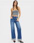 Woman wearing a gray strapless top and blue jeans on a white background